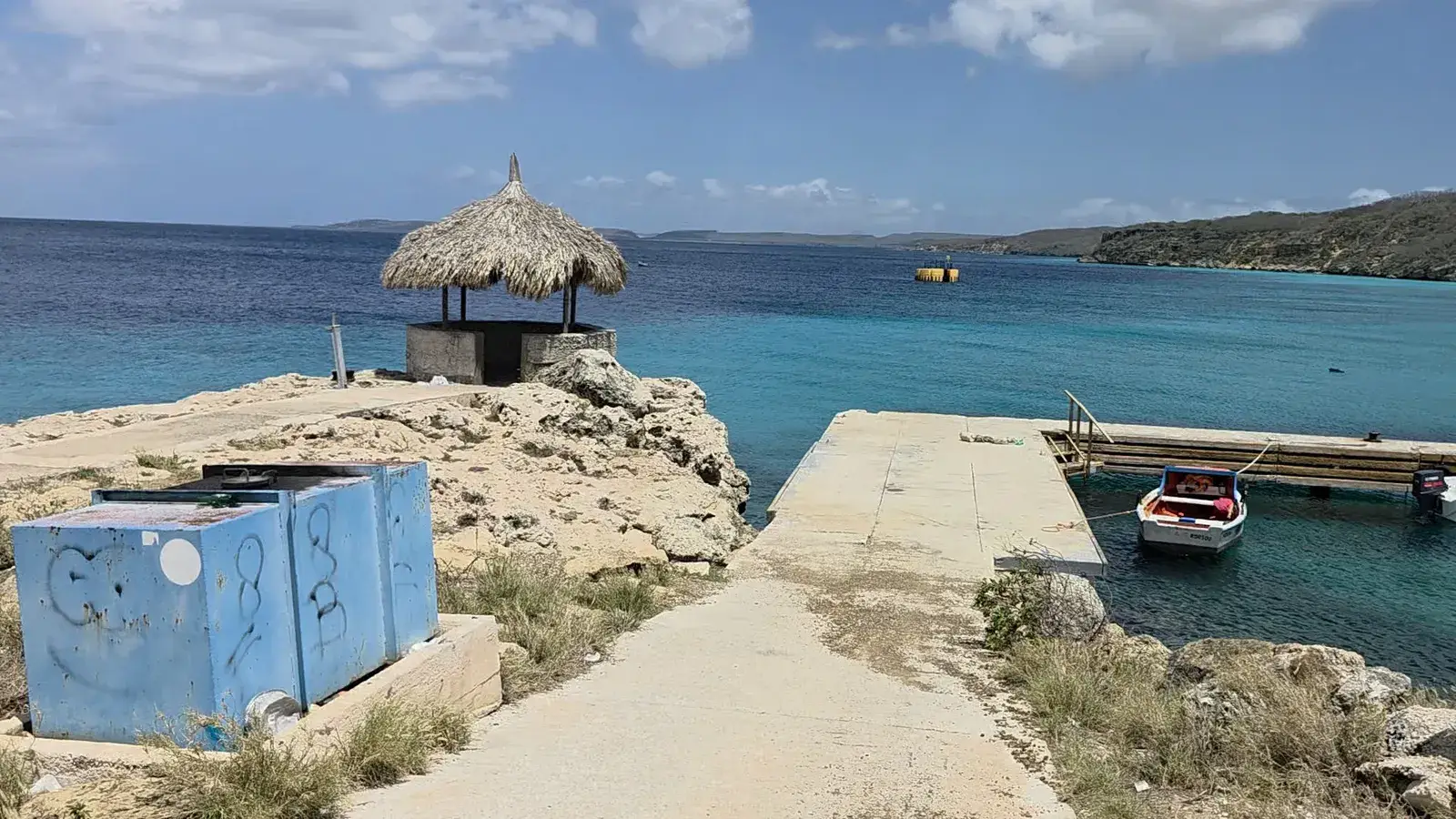 The waterfront expedition site near the Tugboat area in Curaçao with palapa hut, pier and turquoise water